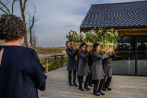 Vrouwelijke dragers met een mand met de bloemenband